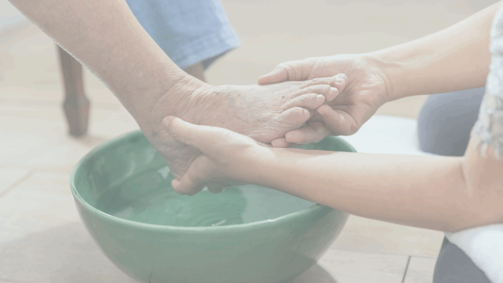 In‑home caregiver assisting an elderly woman with bathing and grooming in a safe, comfortable bathroom.